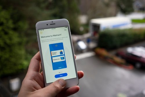 A man launches the Walmart mobile app from his iPhone.  The app is a convenient way to check off your groceries and grocery list.