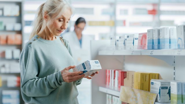 A senior woman shopping for vitamins or supplements in a pharmacy