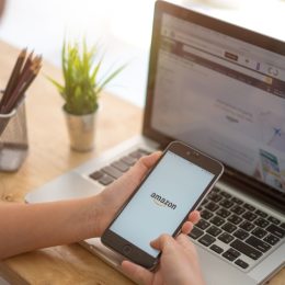 A woman shopping on Amazon using a laptop and phone