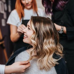 woman with highlights smiling after getting her hair dyed