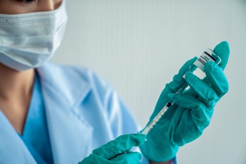 Ein erfahrener Arzt bereitet den Impfstoff vor der Injektion geschickt vor.  Servicekonzept des COVID-19-Impfzentrums.