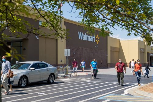 Walmart line outside the store with masked people practicing social distancing 6 feet apart during Covid-19 Corona Virus Pandemic.