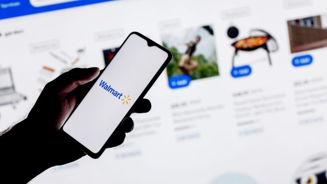 A close up of a person using their smartphone to shop on the Walmart website or app