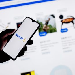 A close up of a person using their smartphone to shop on the Walmart website or app