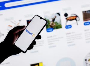 A close up of a person using their smartphone to shop on the Walmart website or app