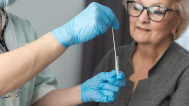A woman about to receive a nasal swab for a COVID test