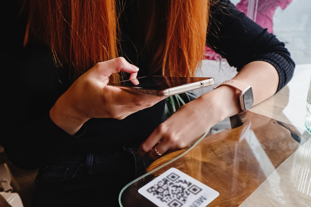 A person scanning a QR code at a business using their phone