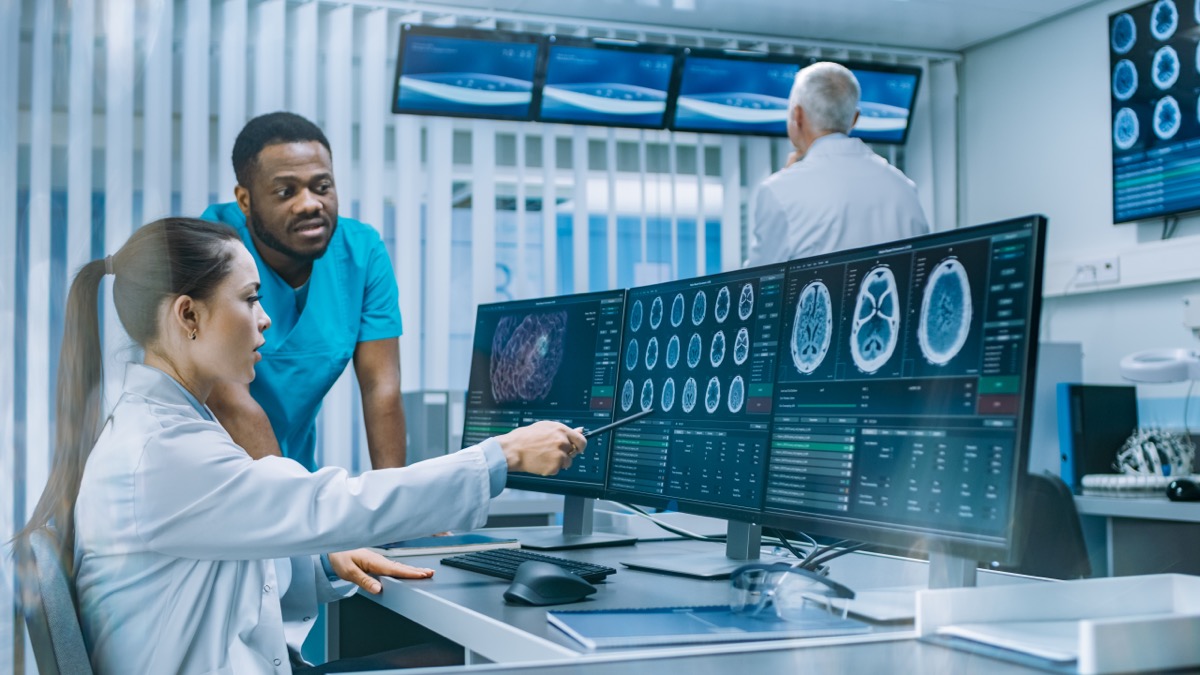Изследователи / лекари, разглеждащи мозъчни сканирания инсулт