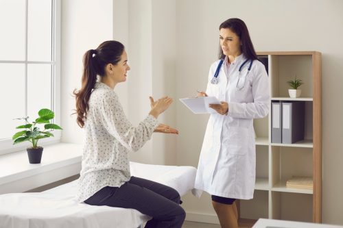 Femeie vorbind cu un doctor
