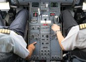 A pilot and copilot sitting in the cockpit of a commercial airliner