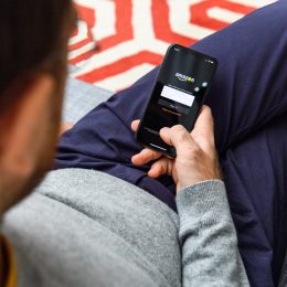 Man using the new Apple iPhone Xs with the immense OLED retina display and a12 bionic chip, looking over the app application Amazon Prime video