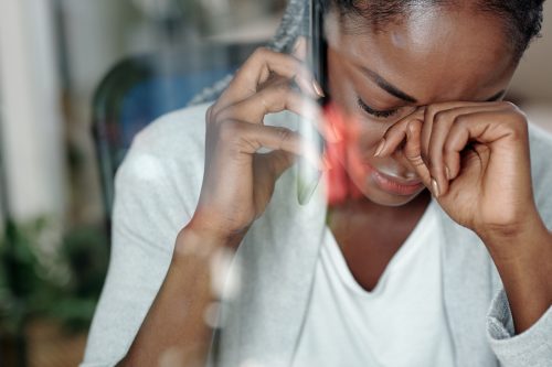 жена плаче, когато получава лоши новини по телефона