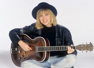 Debbie Gibson posing with a guitar in 1988