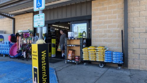March 16, 2022: Shopper carrying a bag of goods out of a Dollar General Corporation store in the Flour Bluff neighborhood of Corpus Christi, Texas
