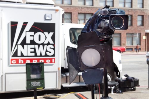 Fox News Truck and Camera on location parked on a street in downtown Los Angeles. Camera and light setup to record an interview on the street in Little Tokyo.