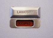 A lavatory sign on a plane bathroom door that says "occupied"