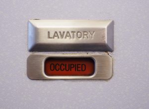 A lavatory sign on a plane bathroom door that says "occupied"
