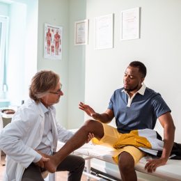 Close up of a doctor having an appointment with a patient with leg pain