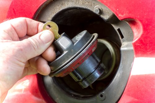 Removing a keyed locked gas cap from a truck.