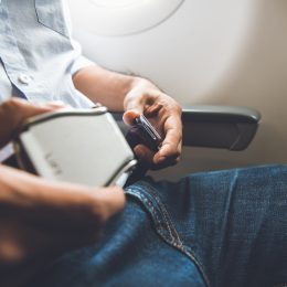 A man buckling his seatbelt on a plane