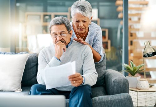 Shot of a mature couple looking worried while going through paperwork together at home