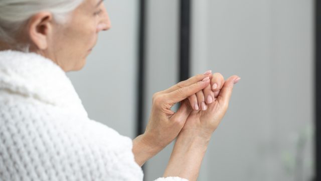 Older woman examining nails