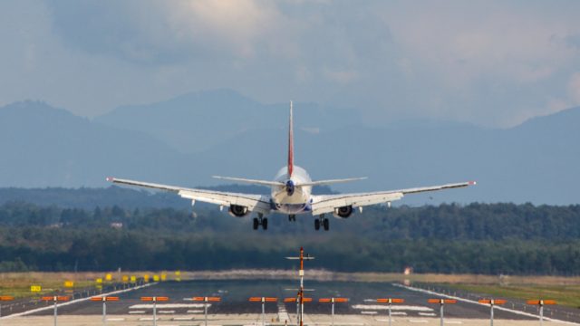 A passenger jet plane landing on a runway at an airport