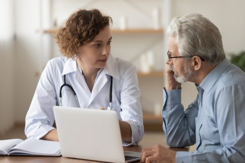Bác sĩ trẻ chuyên nghiệp tư vấn cho bệnh nhân nam lớn tuổi, nói chuyện với khách hàng nam trưởng thành lớn tuổi khi khám bệnh.