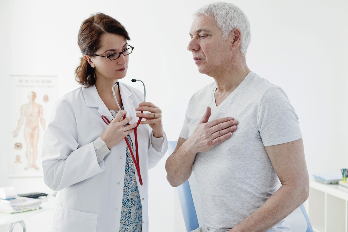 A female doctor is counseling a male patient about heart disease