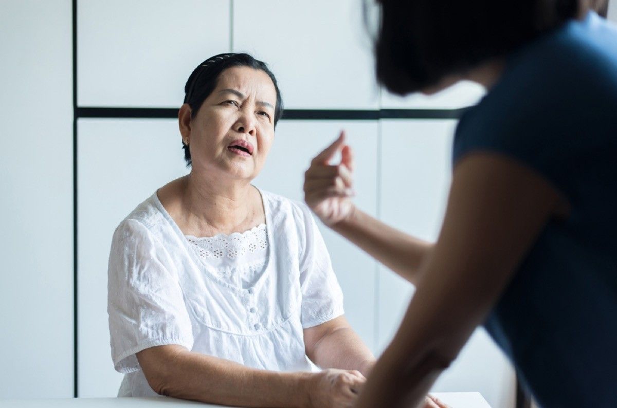 older woman looking confused while another person speaks to her