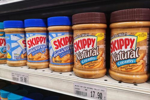 Jars of Skippy brand peanut butter on the supermarket shelf