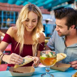 couple sharing tacos at an outdoor restaurant