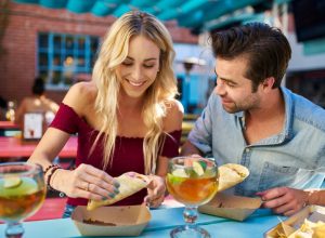 couple sharing tacos at an outdoor restaurant