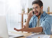 man yelling at computer and gesticulating wildly