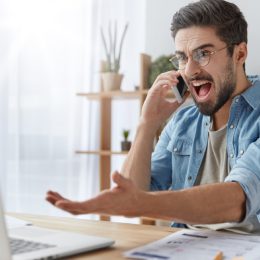 man yelling at computer and gesticulating wildly
