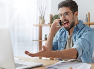 man yelling at computer and gesticulating wildly