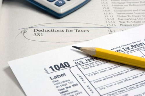 Close-up of 1040 Tax Form with pencil and tax preparation manual