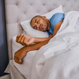 Shot of a young man sleeping in a bed at home