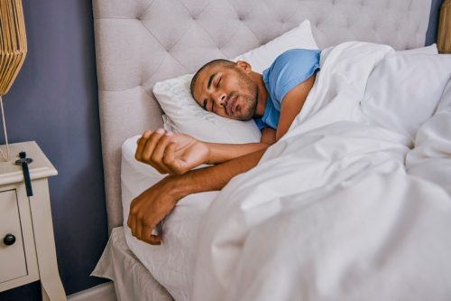 Shot of a young man sleeping in a bed at home