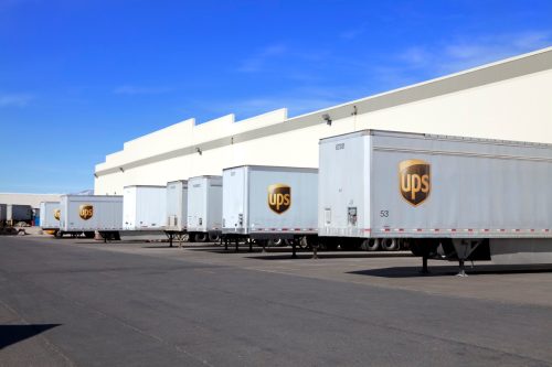 UPS Semi Trailers Lined Up at Warehouse. At a UPS distribution center trailers are parked. The trailers are used to pull haul packages for delivery. UPS is one of the largest online shopping packages delivery system in USA.