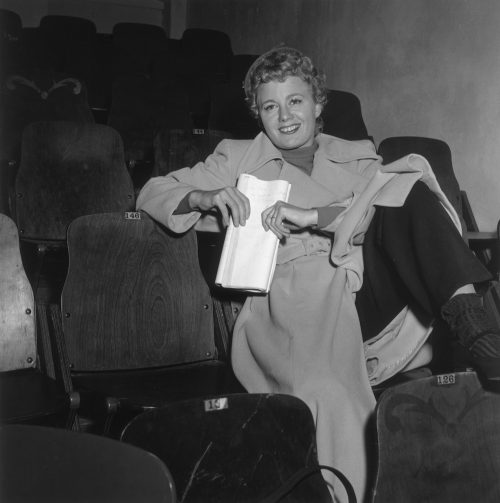 Shelley Winters sitting in a theater circa 1951