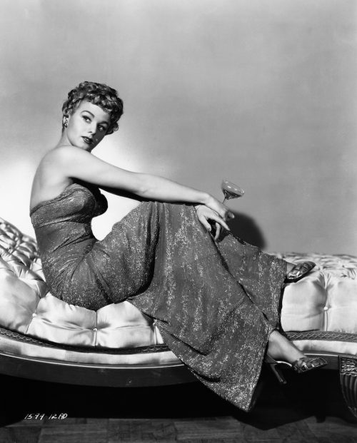 Shelley Winters posing on a chaise lounge in 1951