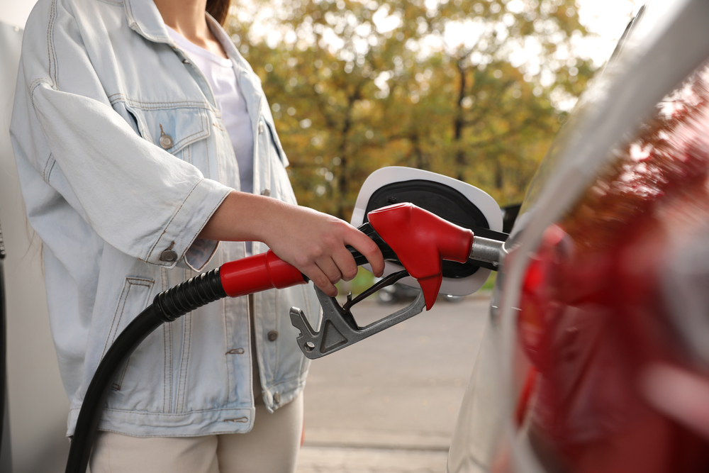 A person filling a car up with gas at a service station