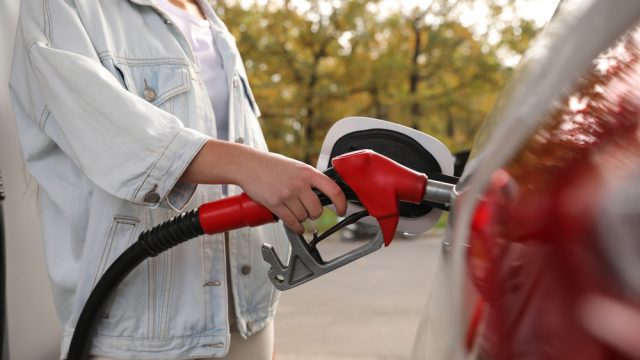 A person filling a car up with gas at a service station