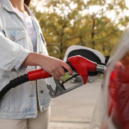 A person filling a car up with gas at a service station