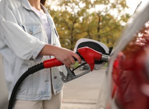 A person filling a car up with gas at a service station