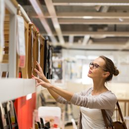 A young woman shopping for chairs in a furniture store