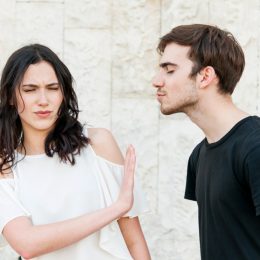 man trying to kiss woman who doesn't want to kiss