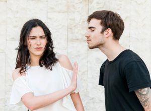 man trying to kiss woman who doesn't want to kiss