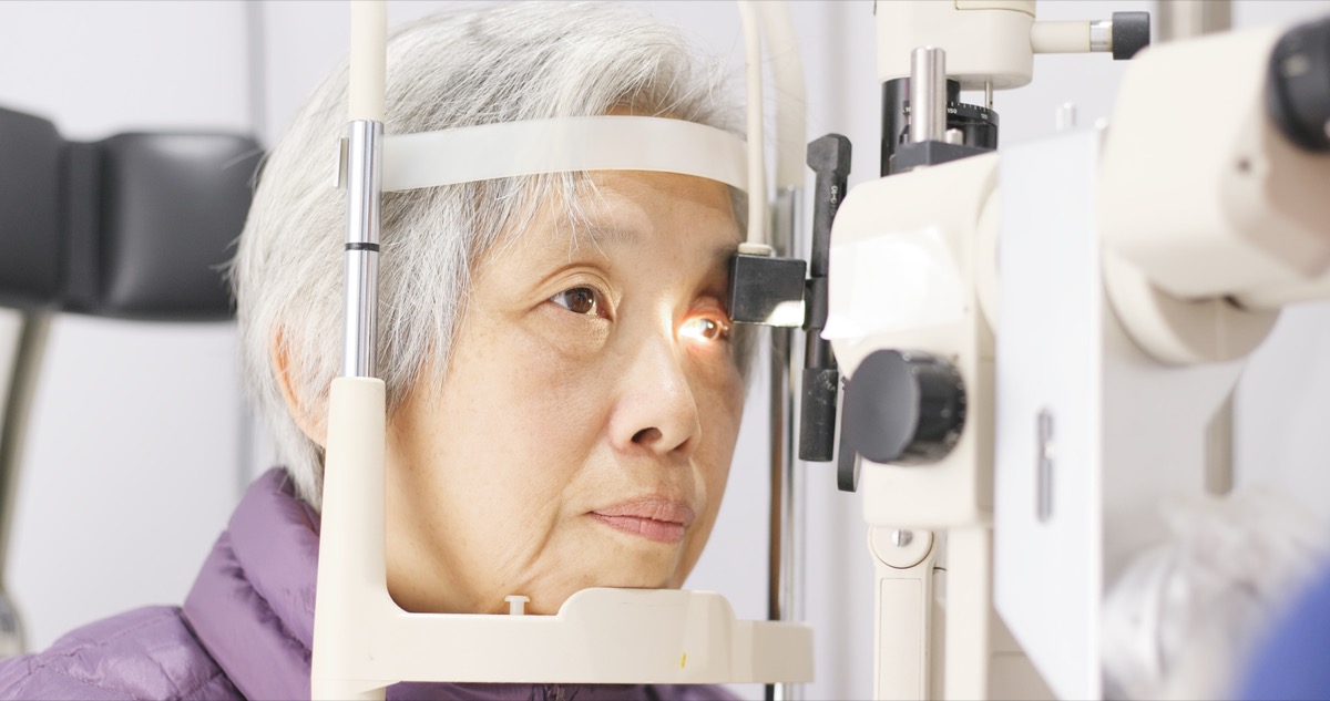 O femeie asiatică în vârstă primește un examen oftalmologic